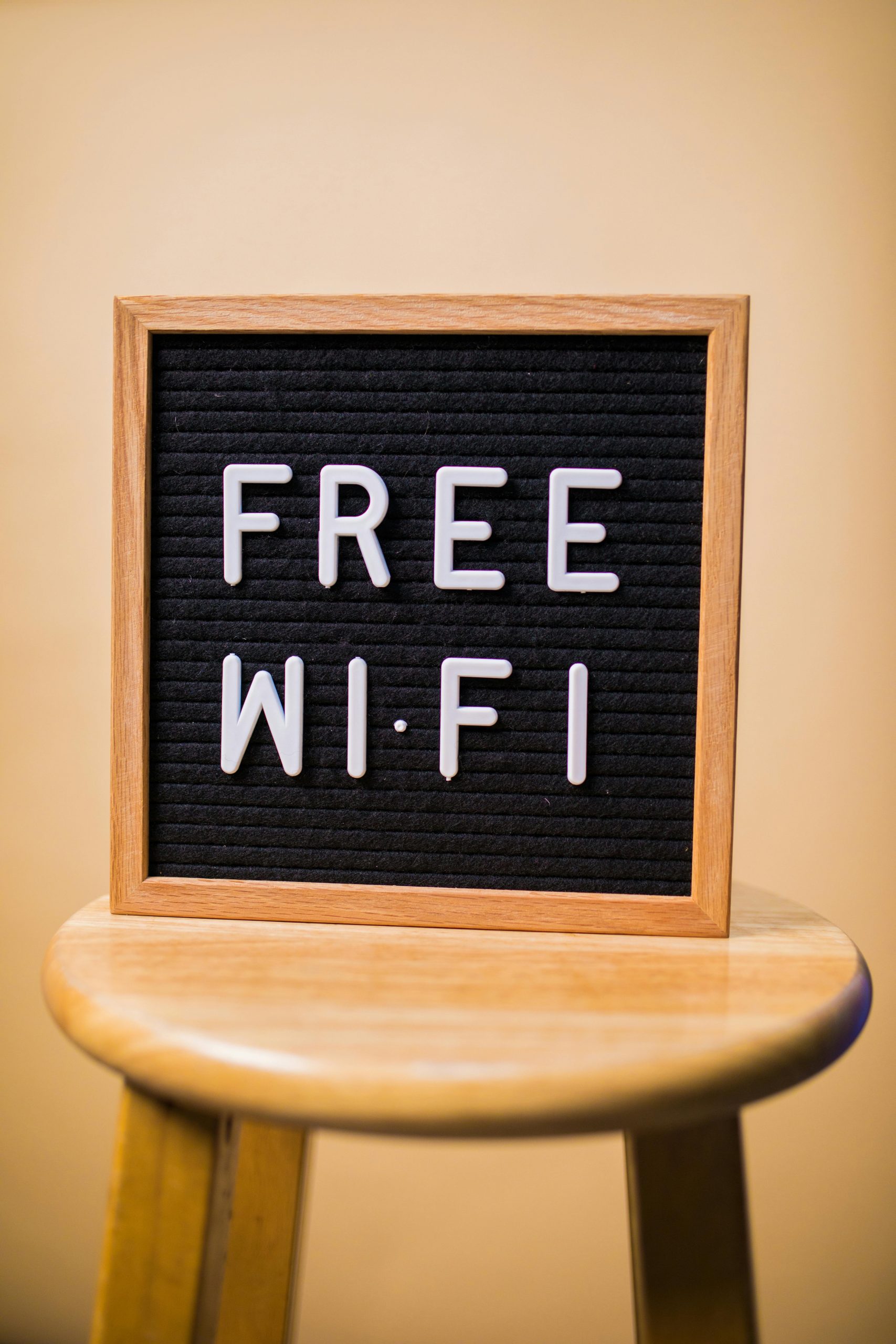 pexels-photo-7563691-7563691 Letterboard displaying 'Free Wi-Fi' on a wooden stool in an indoor setting.